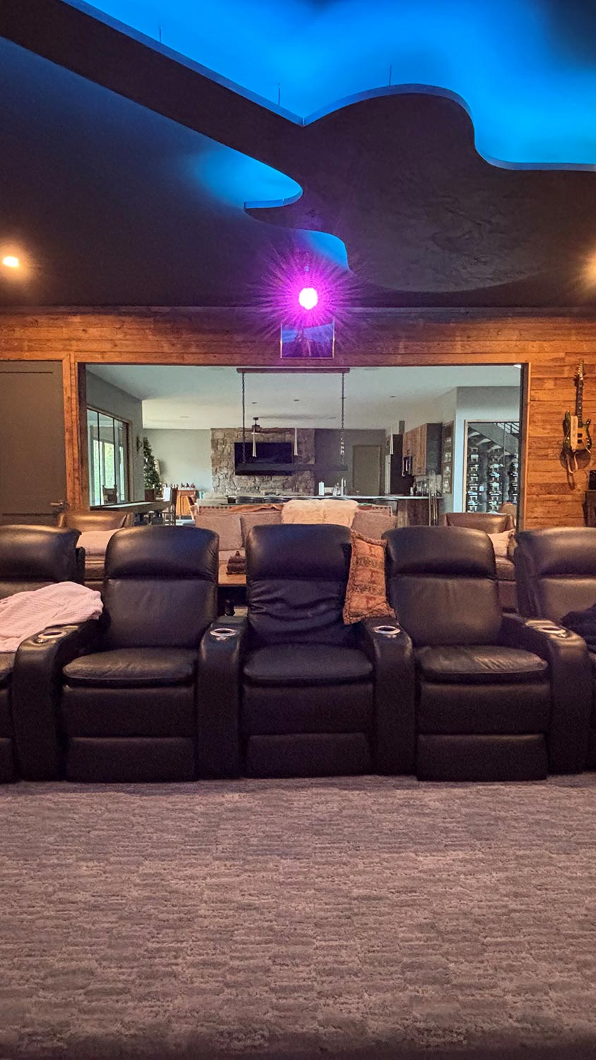 Home theater room featuring black leather recliner seats