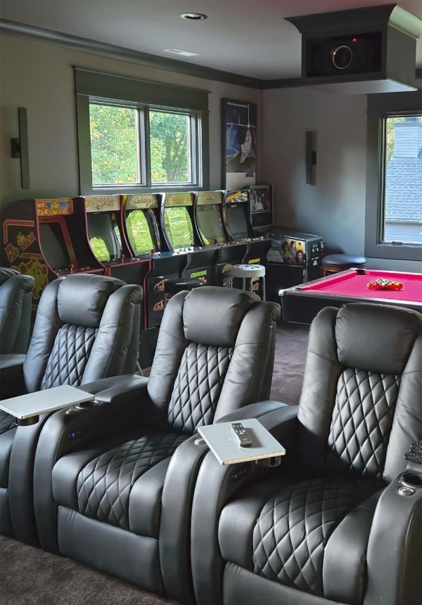 Game room with black theater seats and arcade machines